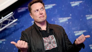 SpaceX owner and Tesla CEO Elon Musk (R) gestures as he arrives on the red carpet for the Axel Springer Awards ceremony, in Berlin, on December 1, 2020.