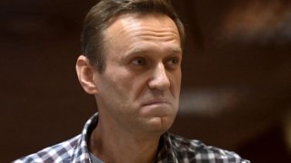 In this Feb. 20, 2021, file photo, Russian opposition leader Alexei Navalny stands inside a glass cell during a court hearing at the Babushkinsky district court in Moscow.