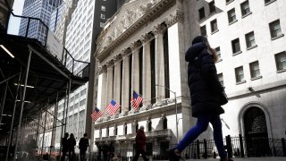 People are seen on Wall St. outside the New York Stock Exchange (NYSE) in New York City, March 19, 2021.