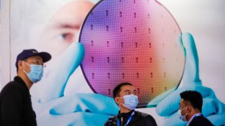 People visit a display of semiconductor devices at Semicon China, a trade fair for semiconductor technology, in Shanghai, China, March 17, 2021.