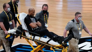 Referee Bert Smith is taken off the court on a stretcher after collapsing during the first half of an Elite 8 game between Gonzaga and Southern California during the first half of an Elite 8 game in the NCAA men's college basketball tournament at Lucas Oil Stadium, Tuesday, March 30, 2021, in Indianapolis.