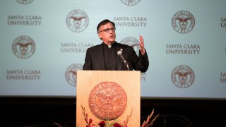 In this March 19, 2019, file photo, Rev. Kevin O'Brien talks to a crowd of people after he was introduced as Santa Clara University president at an event inside Locatelli Student Activity Center on the campus of Santa Clara University in Santa Clara, California.