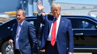US President Donald Trump waves upon arrival, alongside Attorney General of Texas Ken Paxton (L) in Dallas, Texas, on June 11, 2020, where he will host a roundtable with faith leaders and small business owners.