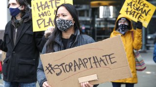 Trish Villanueva (C) of Seattle holds a sign with the hashtag “stop AAPI hate” during the We Are Not Silent rally organized by the Asian American Pacific Islander (AAPI) Coalition Against Hate and Bias in Bellevue, Washington on March 18, 2021. (Photo by Jason Redmond / AFP) (Photo by JASON REDMOND/AFP via Getty Images)