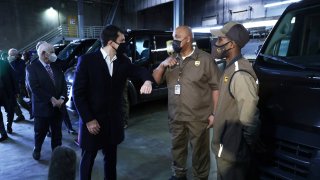 U.S. Secretary of Transportation Pete Buttigieg (L) greets United Parcel Service (UPS) employee Joe Jackson (2nd R) with an elbow bump during a tour at a UPS facility that is delivering vaccines to Washington, DC, and Maryland areas March 15, 2021 in Landover, Maryland.
