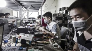 Technicians make repairs to bitcoin mining machines at a mining facility operated by Bitmain in Ordos, Inner Mongolia, China, on Friday, Aug. 11, 2017.