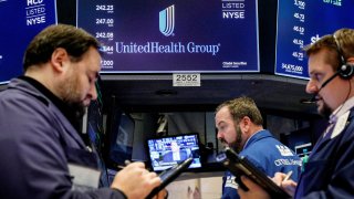 Traders work at the post where UnitedHealth Group is traded on the floor of the New York Stock Exchange.