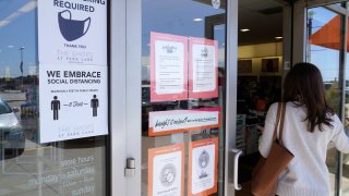 FILE - A customer enters a store with a face mask required sign displayed in Dallas, in this Tuesday, March 2, 2021, file photo. Although nearly a fifth of U.S. states don't require people to wear masks to protect against COVID-19, some businesses are requiring employees and customers to be masked on their premises.