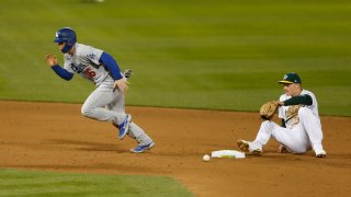 Will Smith of the Los Angeles Dodgers runs to third base after colliding with Matt Chapman of the Oakland Athletics.