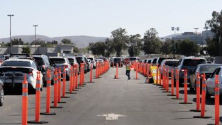 Cars line up to receive a Johnson & Johnson COVID-19 vaccine at the drive-through vaccination site at Six Flags Hurricane Harbor (Waterworld) in Concord, Calif., on Wednesday March 31, 2021. The vaccine is available to people who live or work in Contra Costa County and are 16 years or older.