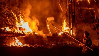 A firefighter tends to a structure lost during the Kincade fire off Highway 128, east of Healdsburg, California on October 29, 2019.