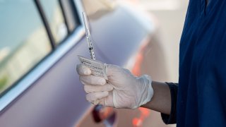 A healthcare worker holds a syringe with a dose of the Pfizer-BioNTech Covid-19 vaccine at a clinic in McClellan, California, U.S., on Thursday, April 1, 2021. Starting April 1, Californians ages 50 and older are eligible to get the Covid-19 vaccine. Photographer: David Paul Morris/Bloomberg via Getty Images