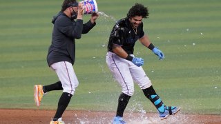 Miami Marlins' Miguel Rojas pours a bucket of water onto Jorge Alfaro after Alfaro hit a double to drive in the winning run in the 10th inning of the team's baseball game against the San Francisco Giants, Saturday, April 17, 2021, in Miami. The Marlins won 7-6.