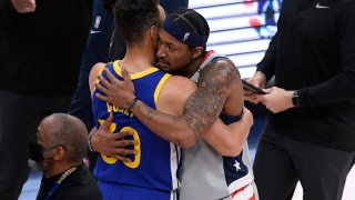 Golden State Warriors guard Stephen Curry, left, and Washington Wizards guard Bradley Beal, right, hug after an NBA basketball game, Wednesday, April 21, 2021, in Washington. The Wizards won 118-114. (AP Photo/Nick Wass)
