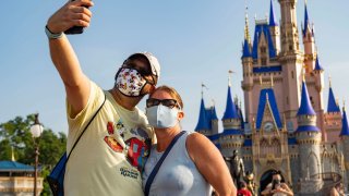 In this handout photo provided by Walt Disney World Resort, guests stop to take a selfie at Magic Kingdom Park at Walt Disney World Resort on July 11, 2020 in Lake Buena Vista, Florida.