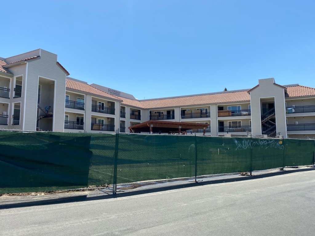 A photo of the Country Inn & Suites by Radisson in Vallejo, surrounded by a fence for construction.