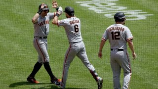 Evan Longoria #10, Steven Duggar #6, and Alex Dickerson #12 of the San Francisco Giants celebrate.