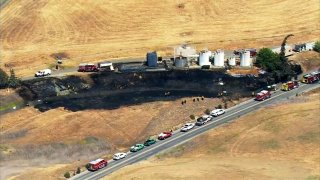 Firefighters work at the scene of a brush fire in the Martinez area.