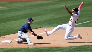 Oakland Athletics' Matt Olson, right, is tagged out on a passed ball by Tampa Bay Rays' Joey Wendle during the eighth inning of a baseball game in Oakland, California, Sunday, May 9, 2021.