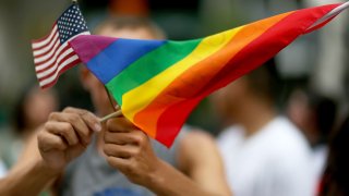 A protester holds an American flag and rainbow flag during a demonstration in Miami.