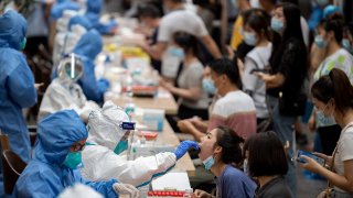 A citizen reacts to a throat swab sampling during a mass covid test in Guangzhou in south China’s Guangdong province Monday, May 31, 2021.