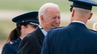 President Joe Biden, with a brood X cicada on his back, walks to board Air Force One upon departure, Wednesday, June 9, 2021, at Andrews Air Force Base, Md.