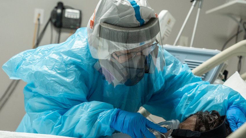 Medical staff member Mantra Nguyen installs a new oxygen mask for a patient in the Covid-19 intensive care unit (ICU) at the United Memorial Medical Center in Houston, Texas.