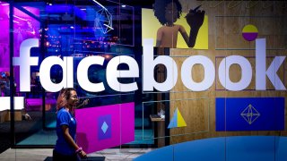 A conference worker passes a demo booth at Facebook's annual F8 developer conference