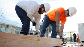 Two men construct a frame to hold concrete at one of the vocational classes at the O.H. Close Youth Correctional Facility