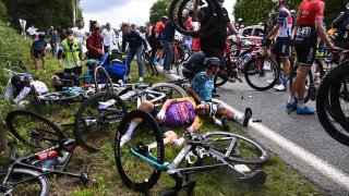 Italy's Kristian Sbaragli, left, and France's Bryan Coquard, right, lie on the ground after crashing during the first stage of the Tour de France