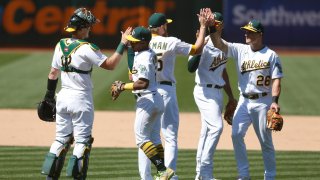 Oakland Athletics players Sean Murphy #12, Tony Kemp #5, Jake Diekman #35, Matt Olson #28 and Matt Chapman #26 celebrate a win.