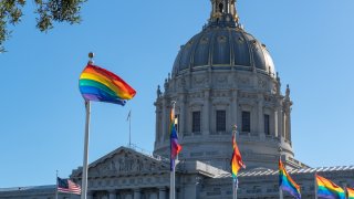 A number of gay Pride flags flying outside of San Francisco City Hall
