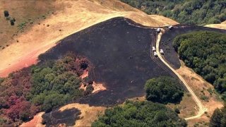 Firefighters work at the scene of a brush fire in Marin County.