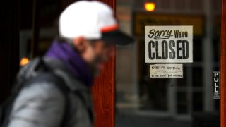 A pedestrian walks by a closed sign on the door of a restaurant on March 17, 2020 in San Francisco, California. (Photo by Justin Sullivan/Getty Images)