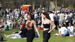 Members of the public walk on a sunny day in the Vondelpark in Amsterdam on March 30, 2021.