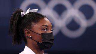 Simone Biles of Team United States watches her team perform on bars after pulling out of the competition after only competing on the vault during the Women’s Team Final on day four on day four of the Tokyo 2020 Olympic Games at Ariake Gymnastics Centre on July 27, 2021 in Tokyo, Japan.