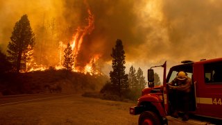 Photo of a firefighter heading toward a wildfire