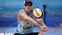 Tri Bourne, of the United States, returns a shot during a men's beach volleyball match against Switzerland at the 2020 Olympics, Wednesday, July 28, 2021, in Tokyo, Japan.