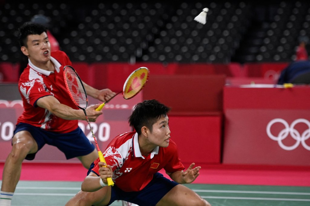 China's Wang Yilyu (L) hits a shot next to China's Huang Dongping in their mixed doubles badminton