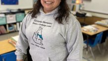 Principal Lourdes Beleche stands smiling in a classroom