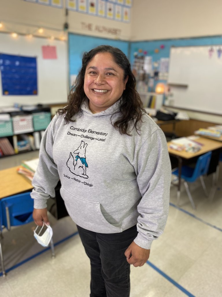 Principal Lourdes Beleche stands smiling in a classroom