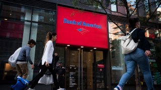 Pedestrians pass in front of a Bank of America Corp. branch in New York.