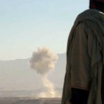 A Northern alliance Mujahed looks on as a U.S. aircraft release its load of bombs, Nov. 7, 2001.