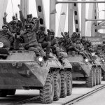 Soviet Army soldiers wave their hands as their last detachment crosses a bridge on the border between Afghanistan and then Soviet Uzbekistan near the Uzbek town of Termez, Feb. 15, 1989.