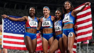Team United States celebrates winning the silver medal in the final of the women's 4 x 100-meter relay at the 2020 Summer Olympics, Friday, Aug. 6, 2021, in Tokyo.
