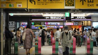 Passengers pass through the gates of a subway station in Tokyo