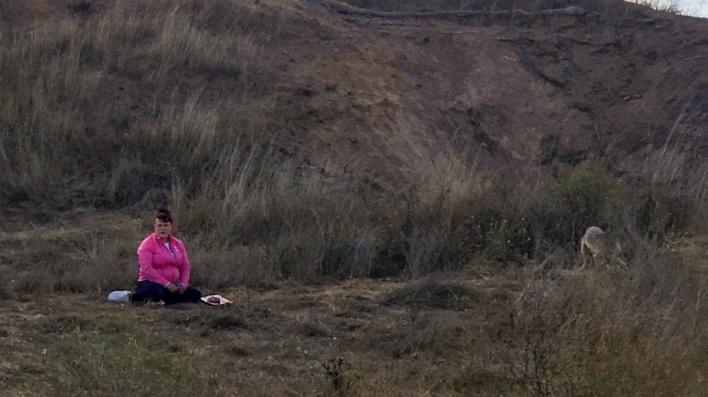 A woman with a platter of meat sits on the ground on Bernal Hill in San Francisco, Calif.