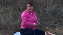 A woman with a platter of meat sits on the ground on Bernal Hill in San Francisco, Calif.