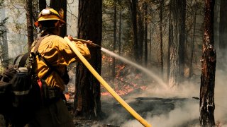 A firefighter works to extinguish a control burn in Greenville, California.