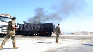 A picture taken on August 15, 2021, shows Lebanese army soldiers inspecting the site of a fuel tank explosion in the village of Tlel in Lebanon's northern region of Akkar.